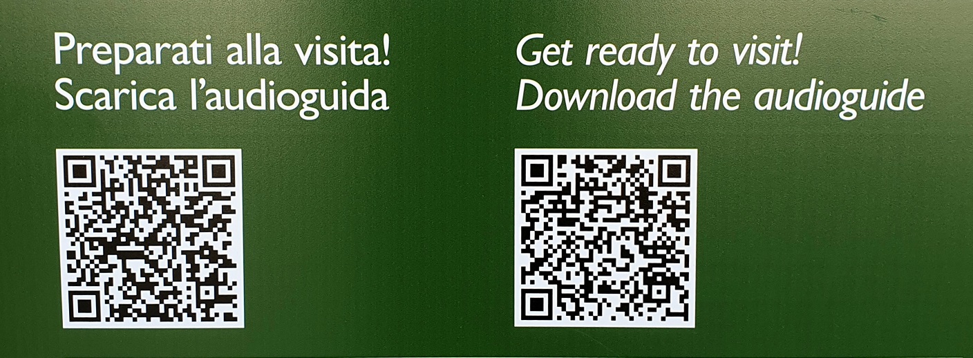 Dettaglio di cartello con codici QR e testo in italiano, “Preparati alla visita! Scarica l’audioguida” e in inglese, “Get ready to visit! Download the audioguide”